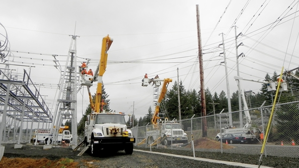 Central Lincoln crews transfer the final conductor to the newly built steel stru