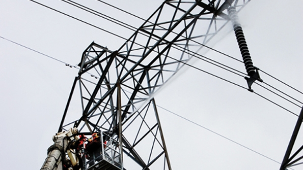 Technicians wash insulators from the platform of a Bronto aerial on live 500kV lines