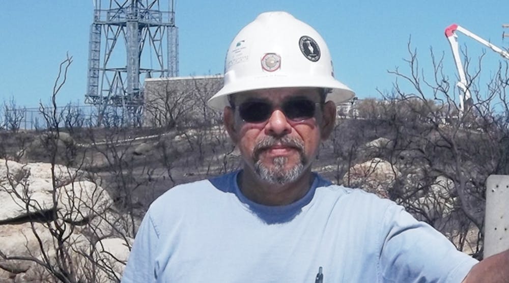 Patrick Flores is shown on the site of restoration in Warner Springs, California. Lightning caused a fire in San Diego County, and Flores and his crew were assigned to rebuild lines and restore power to a rural community.