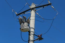 An overhead electricity pole and power lines An overhead electricity pole and power lines