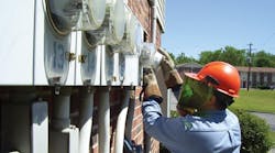 A DPU employee installs an AMI electric meter at a multi-resident building.