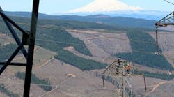 A BPA line maintenance crew makes an urgent repair with helicopter support in a rugged setting near Mount Hood.