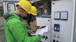 PSE&amp;G engineers review a wiring diagram in preparation of testing the alarm inputs on the SEL 2414 transformer monitoring equipment.