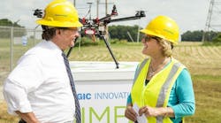 Consumers Energy launched an unmanned aerial vehicle (UAV) near a Jackson County electric substation on June 22, 2015, to help determine whether the emerging technology can improve how the company serves Michigan residents. U.S. Sen. Gary Peters talks with Mary Palkovich, Consumers Energy&rsquo;s vice president of energy delivery, at the launch site.
