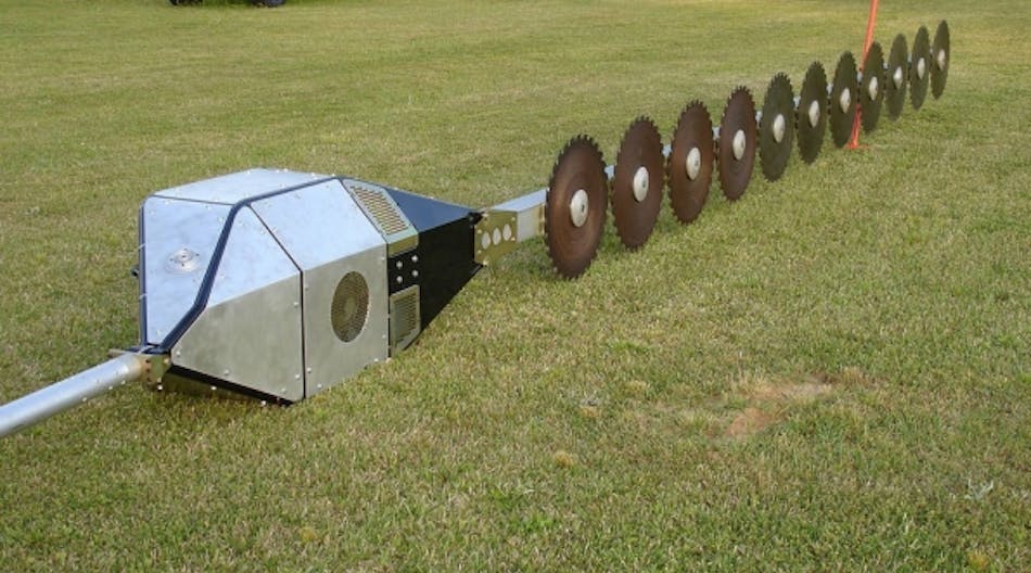A close-up of the aerial saw on the ground, with rotary blades and box housing the motor.