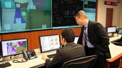 PNNL&apos;s Power Grid Integrator has demonstrated up to a 50 percent improvement in forecasting future electricity needs over several commonly used tools. Project lead Luke Gosink, right, consults on the use of the new tool, which could save millions in wasted electricity costs.