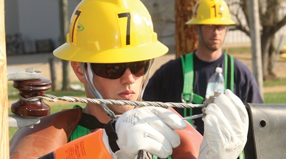 At the Marshall Training Center, an apprentice uses proper cover up and personal protective equipment while practicing a de-energized secondary connection from the ground.