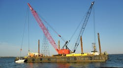 A barge-mounted crane is used for placement of concrete foundation systems needed to cross the Albemarle Sound.