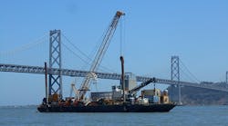 A barge carrying submarine 230-kV cable for a PG&amp;E transmission and substation upgrade project sails under the Bay Bridge between San Francisco and Oakland.