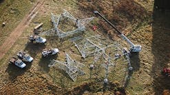 Crews lace lattice tower sections on the ground. The new galvanized steel structures replaced Cor-Ten structures built in the 1960s.