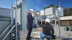 Duke Energy engineers inspect a meter structure and uninterruptible power supply that provide microgrid communications equipment support for the interoperability demonstration.