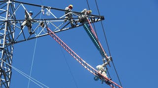 Wearing conductive suits, Manitoba Hydro live-line crew bonds to the conductor to perform energized work, using the barehand ladder method at 500-kV HVDC.