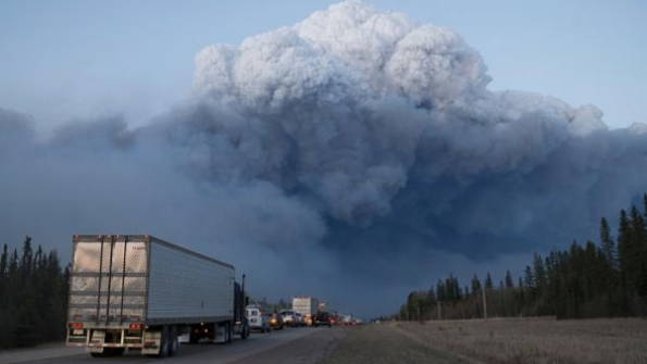 Drivers wait for clearance to take firefighting supplies into town on May 5 2016 outside of Fort McMurray Alberta Wildfires which are still burning out of control have forced the evacuation of more than 80000 residents from the town