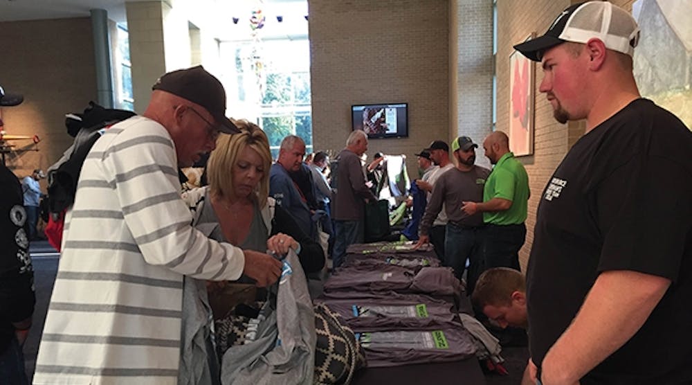 Linemen display their T-shirts on long tables lining the space outside the exhibit hall at the convention center.