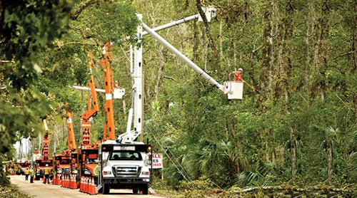 Vegetation clearing contractors for Florida Power &amp; Light help clear fallen debris and trees along neighborhood power lines in Oak Hill, Florida.