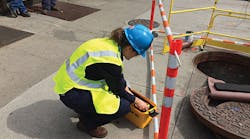 Colleen Murach, a Con Edison technical associate, removes an infrared camera from its packaging for an underground crew working on a Brooklyn street.