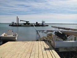 In the tidal marsh area, steel pipe stringers are floated into Hamlin Sound for pipe pullback into horizontal directional drilled holes in the earth. In the tidal marsh area, steel pipe stringers are floated into Hamlin Sound for pipe pullback into horizontal directional drilled holes in the earth.