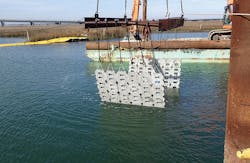 Flexible concrete mats are placed on top of the backfilled trench and pipe in the tidal creek for protection from damage. Flexible concrete mats are placed on top of the backfilled trench and pipe in the tidal creek for protection from damage.