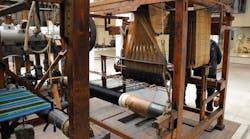 A Jacquard power loom. The wooden punch cards controlling the weave are on the right hand side of the loom.