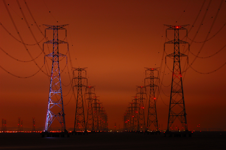 transmission towers against dark sky
