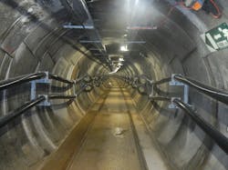 The completed cable tunnel shows two &PlusMinus;320-kV DC cable circuits and grooved rails for robotic vehicle access.