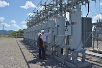 Kootenai Electric engineer Phillip Evander and technician Preston Jerome inspect voltage regulator control at a substation.