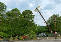 A telephone pole leans after damage from a storm.