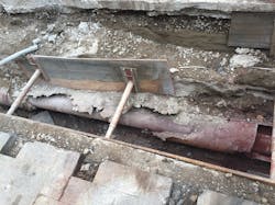 A steam line exposed, resulting in no insulation and the deteriorated outer pipe.