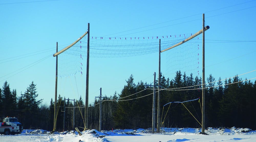 Dielectric safety netting on rider poles is used for stringing over a Manitoba Hydro DC electrode line.