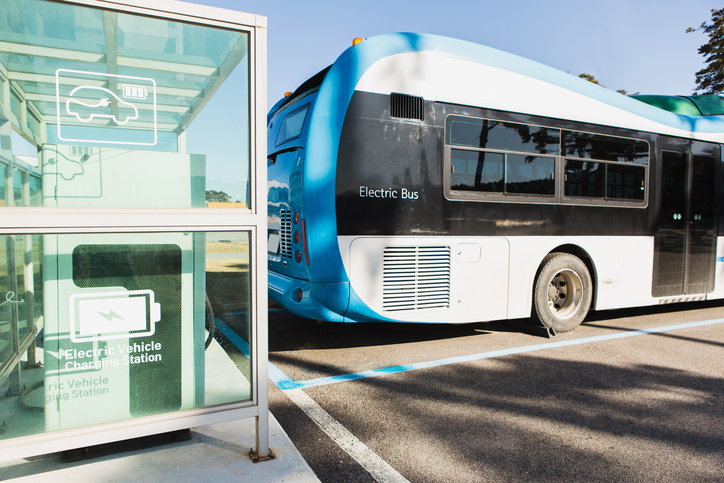 Electric bus is charging on a city street