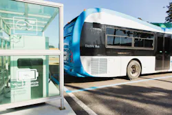 Electric bus is charging on a city street