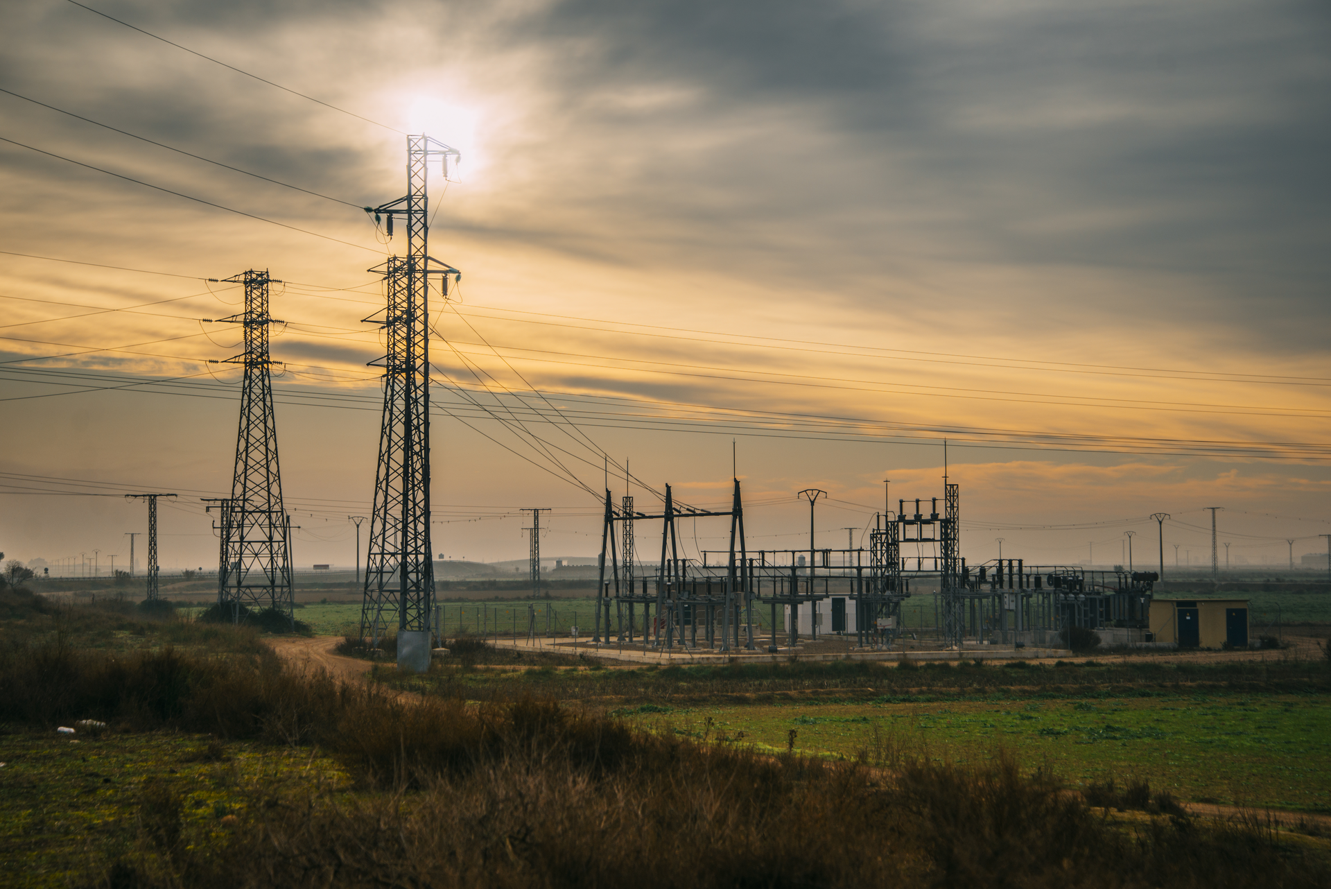 An electricity substation in the countryside at sunrise.