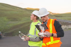 A pair of engineers use a drone to inspect wind farms and power plants in the country A pair of engineers use a drone to inspect wind farms and power plants in the country