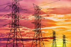 Row of electrical towers with high voltage cables set against a vibrant sunset. Row of electrical towers with high voltage cables set against a vibrant sunset.