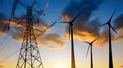 High voltage tower and wind turbines against the sunset