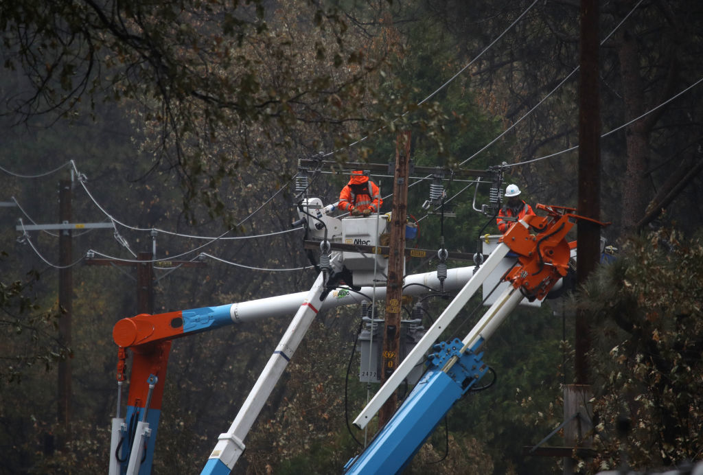 PARADISE, CALIFORNIA - NOVEMBER 21: Pacific Gas and Electric (PG&E) crews repair power lines that were destroyed by the Camp Fire
