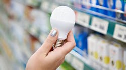 Energy saving LED lamp in hands of buyer at store