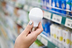 Energy saving LED lamp in the hands of the buyer at the store Energy saving LED lamp in the hands of the buyer at the store
