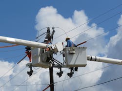 linemen in utility truck working on electrical equipment linemen in utility truck working on electrical equipment