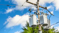 Photo of Electricity Distribution Pole with Transformers aginst Bleu Sky with Clouds
