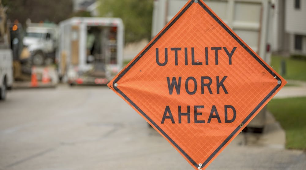 Road construction safety sign, Utility Work Ahead, while repairing a street.