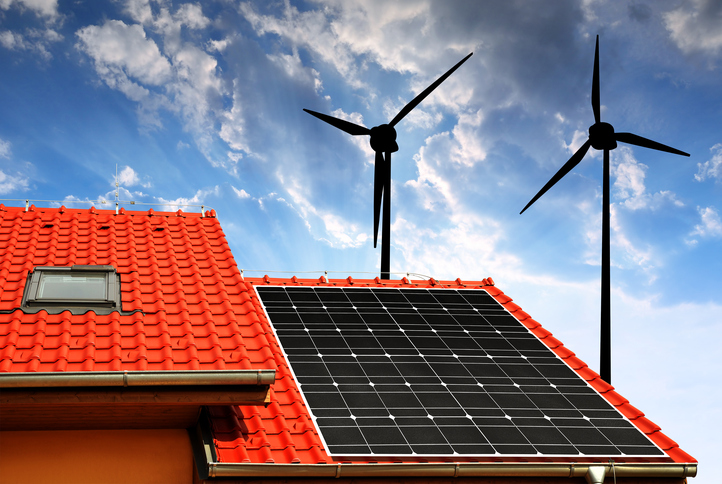 Solar panel on the roof of the house in the background wind turbines at sunset.