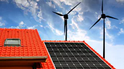 Solar panel on the roof of the house in the background wind turbines at sunset.