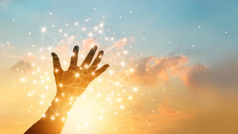 Hand touching global network with sunset in the background