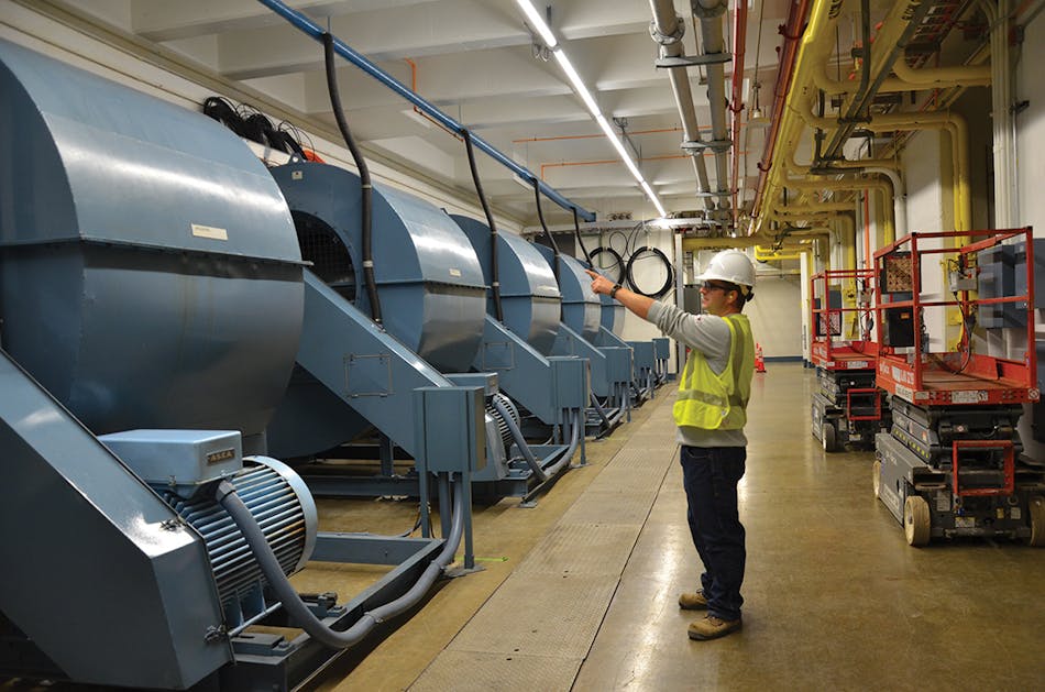 Greg Schutte, HVDC project manager, points out fans in the basement of one of the converter stations. All fans will be removed as the system moves to a water-cooled vs. air-cooled system. Water-cooled valves require significantly less equipment, are more efficient and effective for cooling, and are used on all new HVDC systems built today.