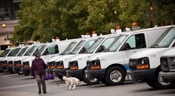 A woman walks with her dog past Con Edison trucks lined up in Union Square in preparation for Hurricane Sandy A woman walks with her dog past Con Edison trucks lined up in Union Square in preparation for Hurricane Sandy