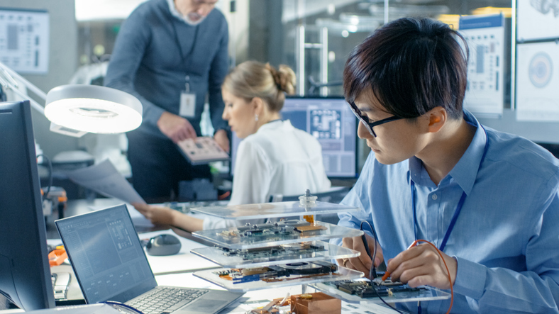 Electronics Engineer Works with Robot, Soldering Wires and Circuits. Computer Science Research Laboratory with Specialists Working.