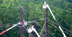 Linemen stand on cranes to work on power lines Linemen stand on cranes to work on power lines