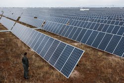A visitor inspects photovoltaic panels at Sishen solar park in Kathu, Northern Cape, South Africa A visitor inspects photovoltaic panels at Sishen solar park in Kathu, Northern Cape, South Africa