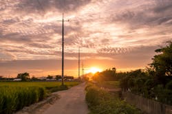 A rural landscape with electric poles and overhead lines A rural landscape with electric poles and overhead lines